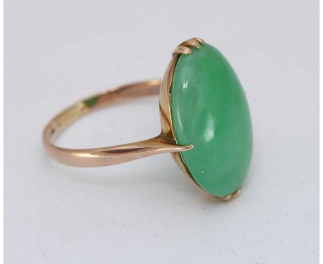 A 14K gold ring, claw-set with an oval cabochon polished jade, measuring 19x14mm, probably Honk Kong