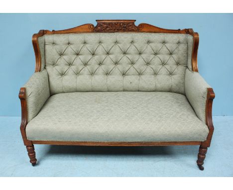 An Edwardian stained walnut sofa, with carved floral decoration, green trellis pattern fabric upholstery, frilled gimp and ra