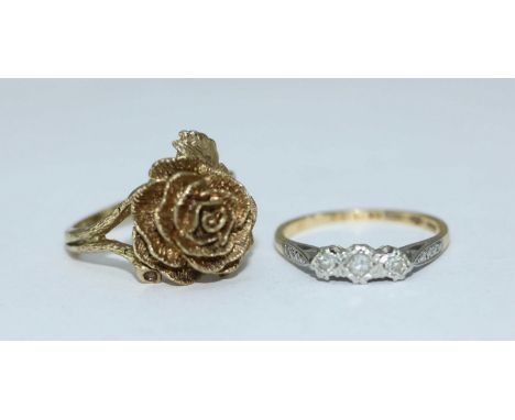 A 9ct gold ring modelled as a rose with leaves and stem forming the shank, 5.25grams, together with a an 18ct three-stone dia