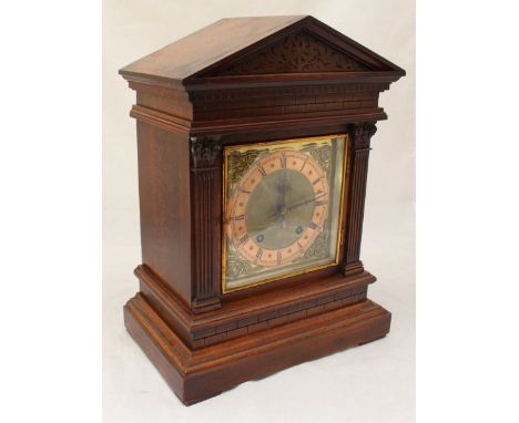 An Edwardian mahogany mantle clock, the sloped top above a brass dial with Roman numerals denoting hours, flanked by two flut