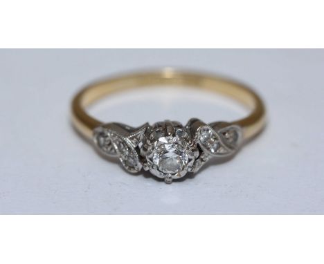 An 18ct gold and diamond ring, centrally set with a rbc diamond, measuring approximately 0.20cts, further set to the shoulder