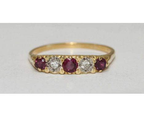 An 18 carat gold antique style ring with carved mount set with three rubies and two diamonds.  Total weight of ring 3.4 grams