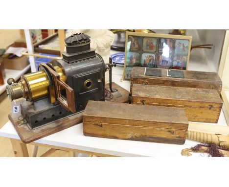 A magic lantern and three wooden boxes of slides and a panel of coloured slides