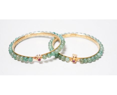 A pair of yellow metal and jade bangles, 7.2cm diameter