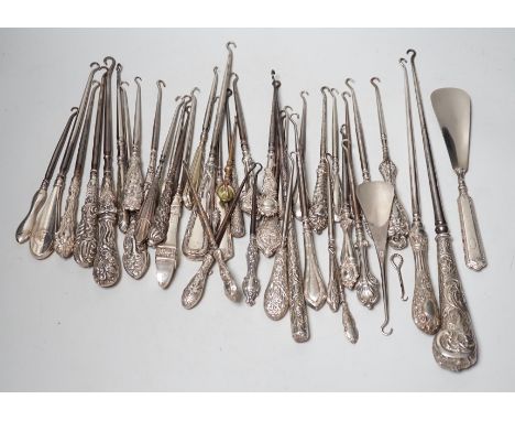 A large collection of mainly silver handled button hooks and two shoe horns.