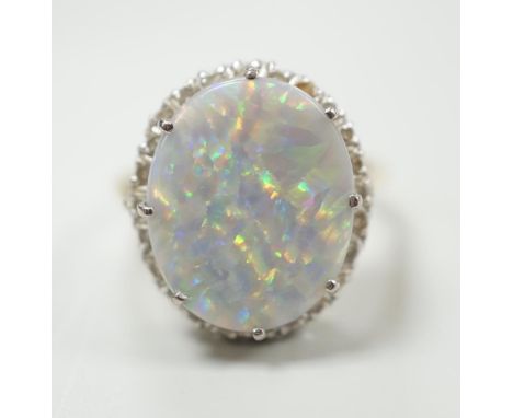 An 18ct, white opal and diamond chip set oval cluster ring, size L, gross weight 8.1 grams.