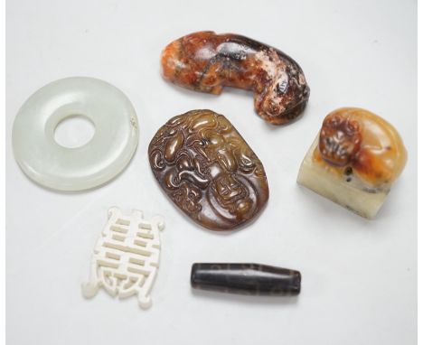A Chinese pale celadon jade bi disc, a jade carving of the character ‘Shou’ , two hardstone carvings of creatures, an agate p