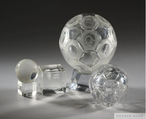 Three glass football awards presented to David Dein MBE, comprising an Orrefors glass football raised upon a square plinth ba