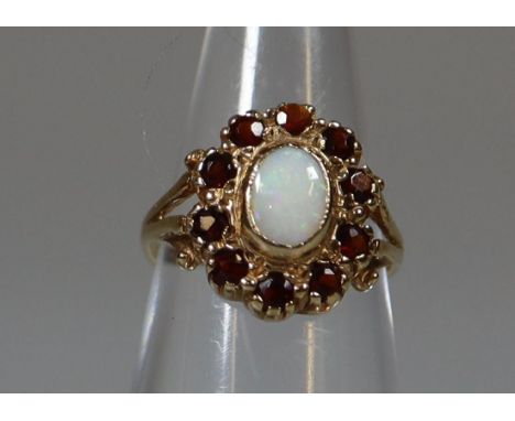 9ct gold opal and garnet oval-shaped dress ring with split shoulders. 1.5g approx.(B.P. 21% + VAT) 