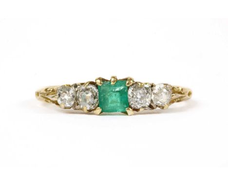 A gold emerald and diamond ring, a square step cut emerald with two old cut diamonds each side, all claw set to a scroll gall