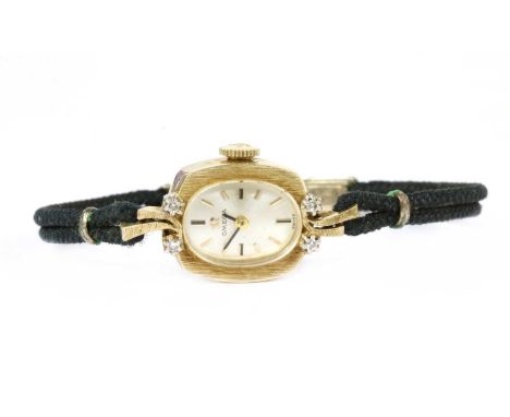 An American gold Omega diamond set cocktail watch, c.1960, cushion shaped case 17 x 14mm, with silvered dial, black and gilt 