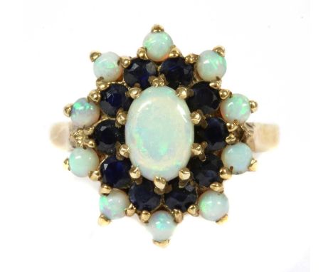 A 9ct gold opal and sapphire cluster ring, an oval cabochon opal with surround of circular mixed cut sapphires and outer row 