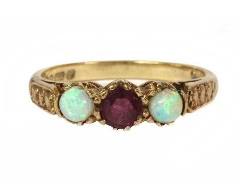 A 9ct gold ruby and opal three stone ring, a circular mixed cut ruby with a cabochon opal at each side, all claw set to taper