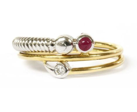 A gold ruby and diamond ring, of three row coiled yellow gold wire form, one end terminating in a round cabochon ruby, rub se