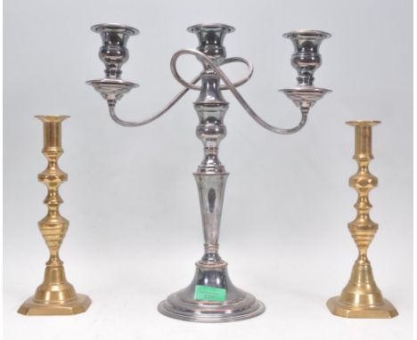 A pair of antique brass candlesticks having knopped columns being raised on square chamfered bases with flared sconces to the