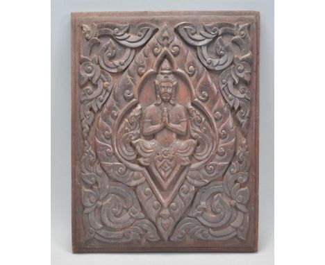 A 19th Century Southeast Asian carved oak wall hanging panel having a central carved God with carved floral and scroll surrou