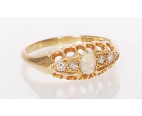 A stamped 18ct gold ladies ring set with an oval cut opal flanked by four white stones in a graduating mount. Weight 3.2g. Si