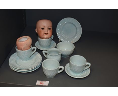 A 20th Century light blue glazed doll's tea set decorated in a lozenge design, together with two bisque porcelain doll's head