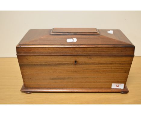 A 19th century figured mahogany tea caddy, of sarcophagus form, the hinged cover lifting to reveal the original central glass