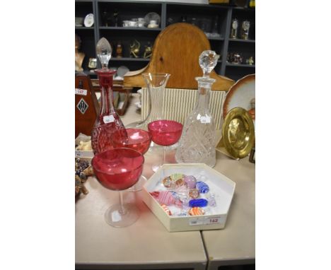 A cut cranberry style glass decanter sold along with three cranberry style glasses as well as two other decanters and a small