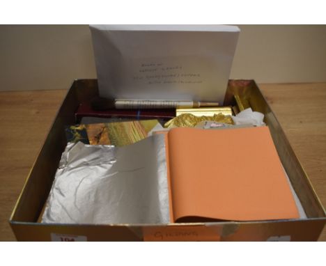 A box of gilding tools and materials including a gilder's cushion, samples of bole and gesso work, and transfers