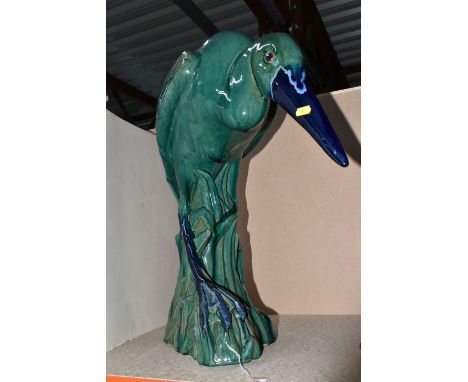 LARGE CERAMIC HERON, pottery study of a heron in a natural setting of reeds, in stooped pose finished in a green glaze with b
