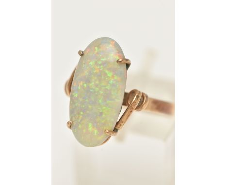 AN OPAL RING, designed as an oval opal cabochon in a four claw setting to the twist design shoulders and plain band, stamped 