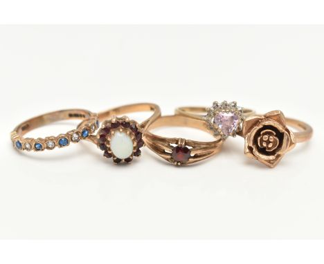 FOUR 9CT GOLD RINGS AND A YELLOW METAL RING, the first a yellow gold floral ring, ring size M 1/2, a cubic zirconia cluster r