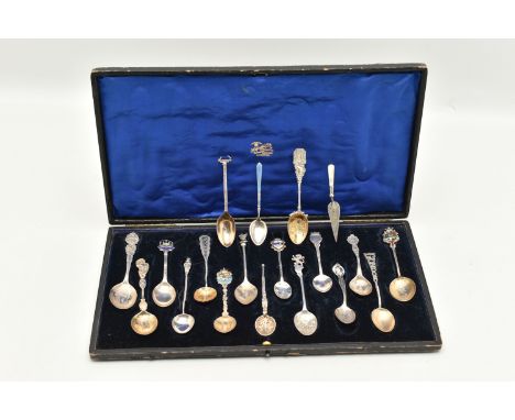 A SELECTION OF EIGHTEEN SOUVENIR TEASPOONS AND A SILVER BOOKMARK, to include a blue enamel Marius Hammer spoon, an Edwardian 