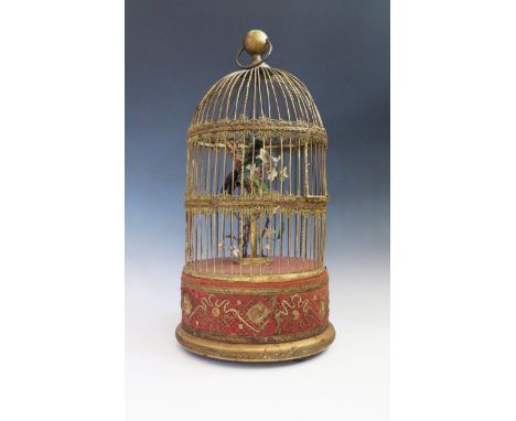 A Large Clockwork Automaton Singing Bird in a gilt cage with gold thread embroidered base, c. 53 cm high