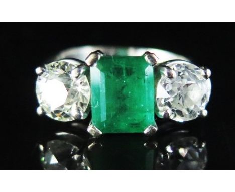 An Emerald and Diamond Three Stone Ring in 18ct white gold setting, size K, 4.5 g. Emerald c. 1.8ct and diamonds c. 1ct each