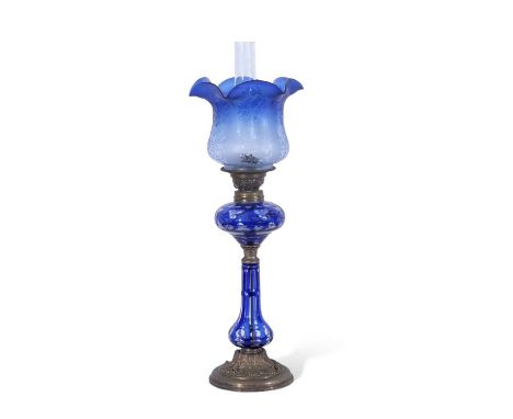 Late 19th century oil lamp, the blue glass shade with floral design above a Bohemian style blue glass reservoir and stem on g
