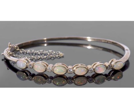 9ct gold opal and diamond set hinged bracelet, the top section with six oval cut cabochon opals, each in cut down settings an