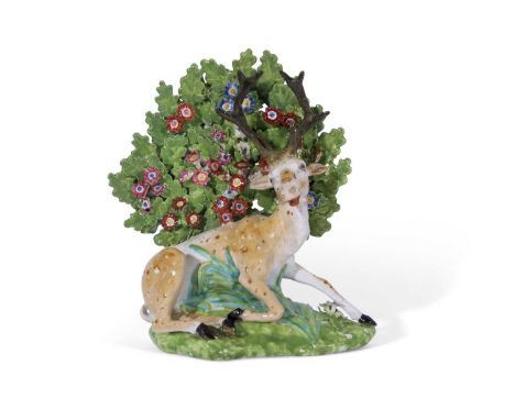 Early 19th century Derby porcelain model of a stag on green ground, red factory mark to base and numerals 29