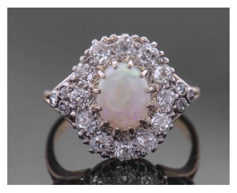 Opal and diamond cluster ring centring an oval shaped cabochon opal, multi-claw set and raised above an old cut diamond surro