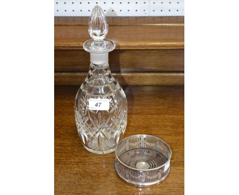 A cut glass decanter on silver plated coaster