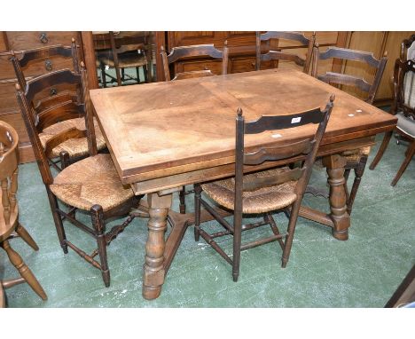 A rustic French elm drawleaf dining table, crossbanded top, turned spreading supports, X-framed stretchers; six rustic ladder