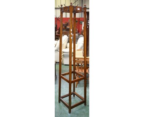 An oak cloak stand, turned finials, spreading square supports.