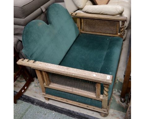 An oak reclining two seat sofa, padded back and seat, wickerworked side panels, barley twist uprights, turned forelegs.