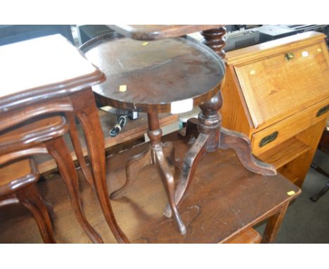A side table raised on tripod base