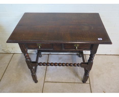 An 18th Century oak side table with a single drawer on bobbin turned supports and front stretcher, with good colour and patin