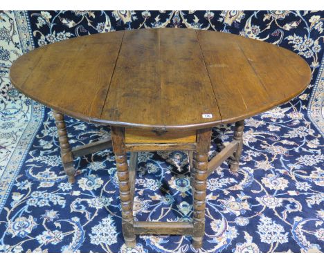 An 18th Century oak gateleg table on bobbin turned  legs and a drawer - 113cm W x 136cm L 