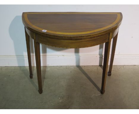 A 19th Century mahogany demi lune fold over card table with an inlaid frieze - 91cm diameter - removed from a Cambridge Colle