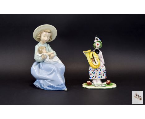 A Nao Figure In The Form Of A Young Girl With Infant Seated figure of a girl in straw hat, seated on her knee is an infant sw