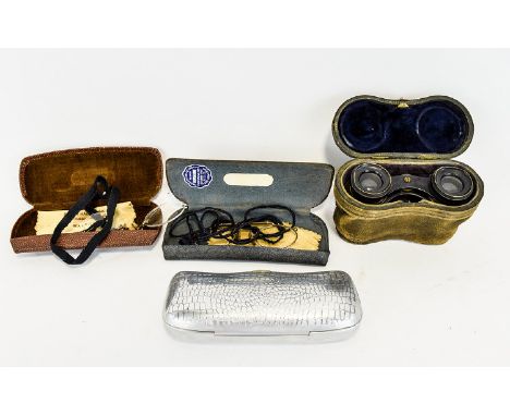 A Pair Of Antique Opera Glasses Housed in original leather case, an unusual example in heavyweight brass with raised hunting 