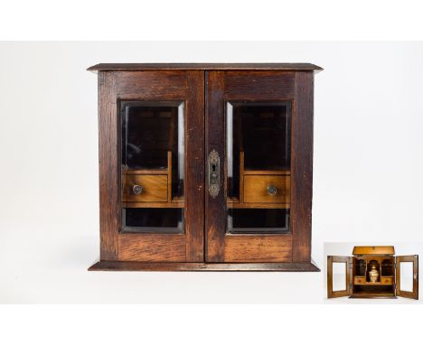 Oak smokers cabinet, double doors with bevelled glass, the interior with 4 drawers, a shelf and space for a humidor. 13 inche