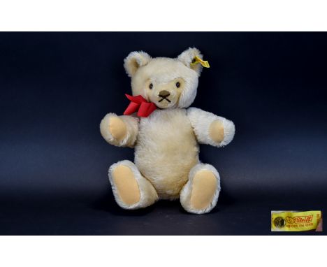 Steiff Bear Jointed blonde mohair bear by Steiff, complete with red ribbon to neck and traditional brass button and yellow la