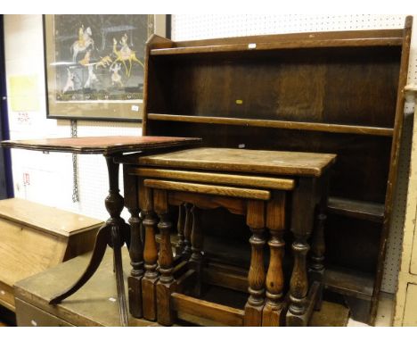 A nest of three oak tables, oak open bookcase and a reproduction side table with shaped red leatherette top, raised on turned