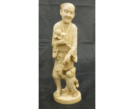 A Japanese Meiji period carved ivory okimono as a man with branch of peaches in his right hand, a rope in his left, a monkey 