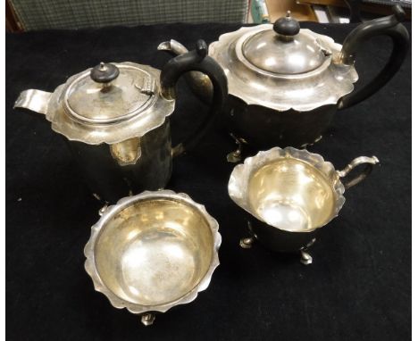 An early 20th Century silver four piece tea service to comprise teapot with ebony finial and handle with crimped edge raised 